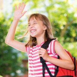 Aws Little Girl With Pink Striped Shirt And Red Backpack Smiling And Waving
