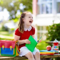 Aws Little Girl In A Red Dress With A Backpack And Books C Laughing