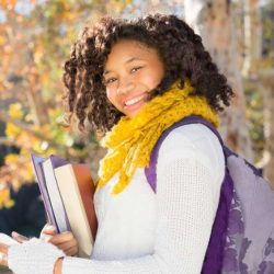 Aws Autumn African American Student In Fall With Phone Holding Books While Smiling