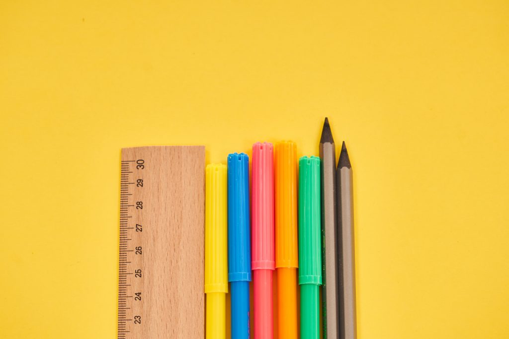 Ruler With Pencils And Colorful Pens On Yellow Background