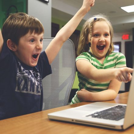 Boy and girl at computer cheering