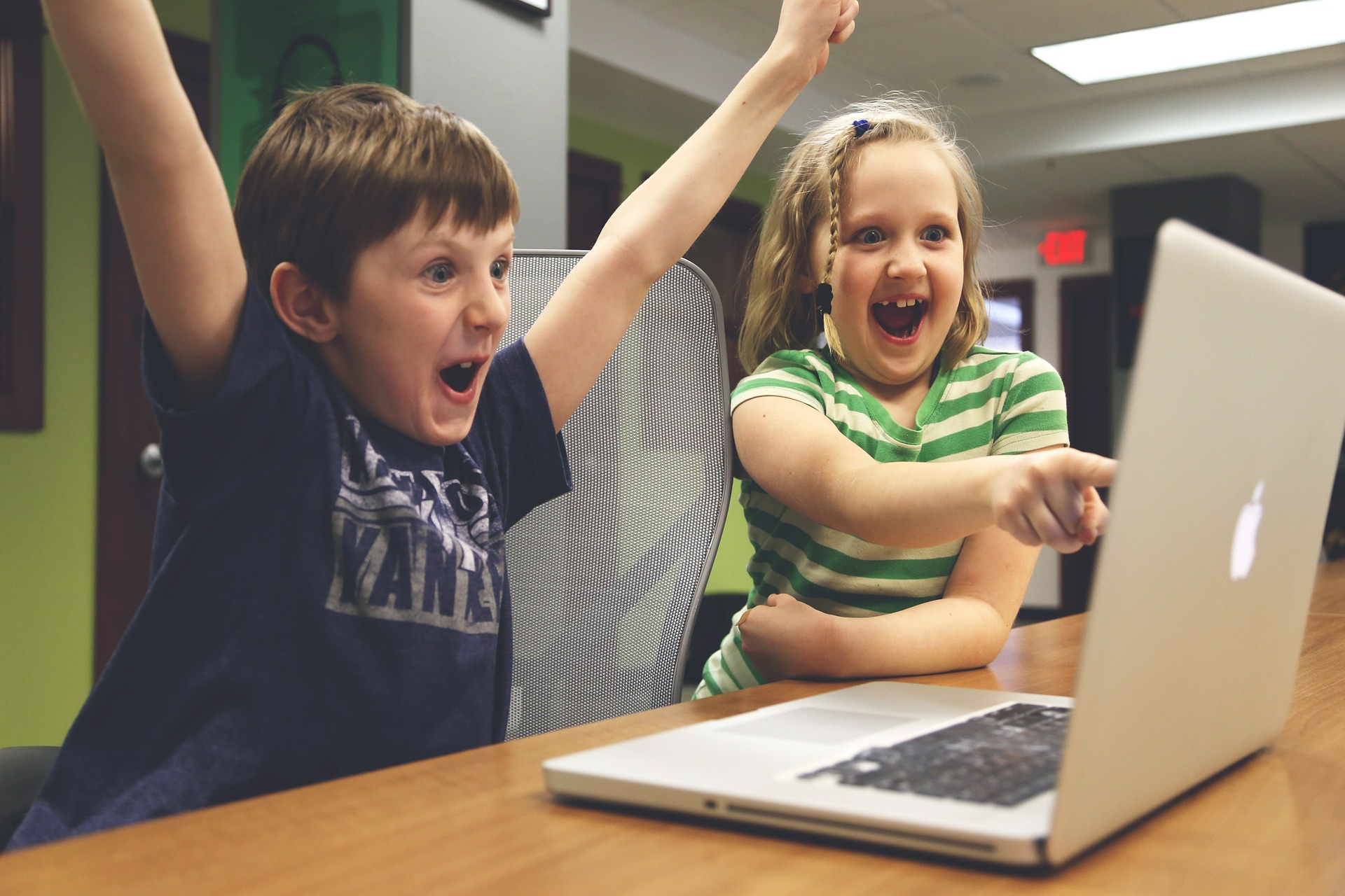 Boy and girl at computer cheering