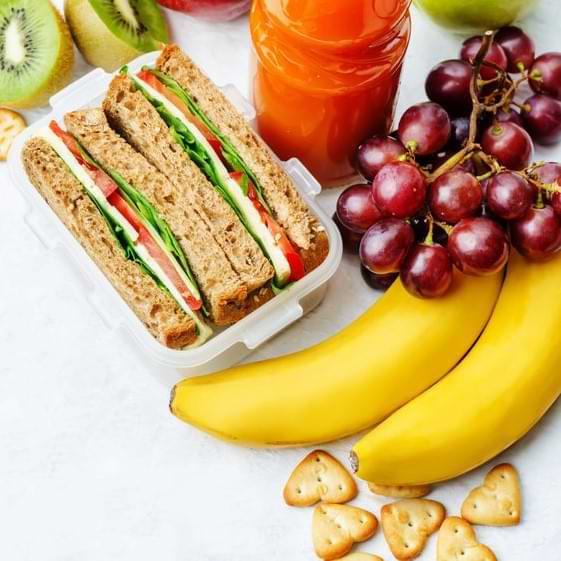 Sandwich C Bananas Cand Grapes On White Table