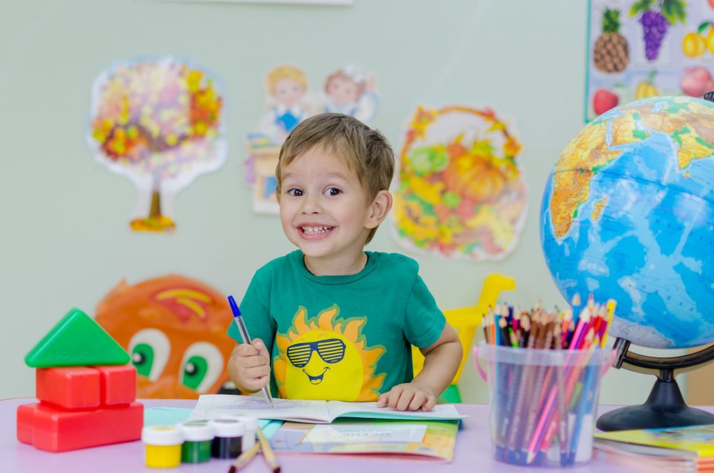 Smiling boy coloring