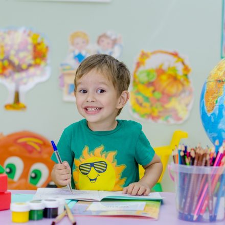 Smiling boy coloring