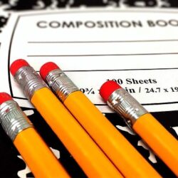 Composition note book with pencils on top