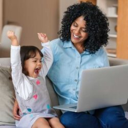 Laughing Little Girl And Mother Watching Something On A Laptop