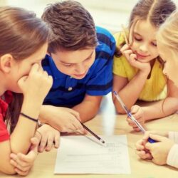 Group Of Students Working On Class Work At Table