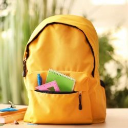 Yellow Backpack With School Supplies Visible From Pocket