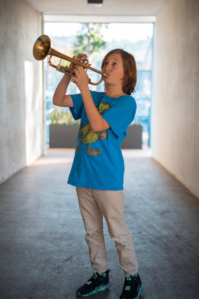 Kid playing trumpet in the hallway